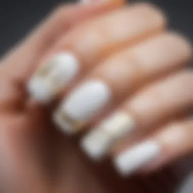 Minimalist white nail art with gold accents